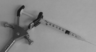 Photograph of a modified syringe being used to inject the sample into the capillary.